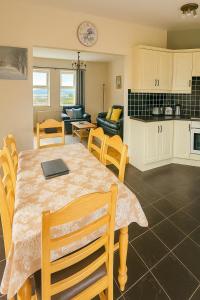 une cuisine et un salon avec une table et des chaises dans l'établissement Heather View Cottage, à Carrigart
