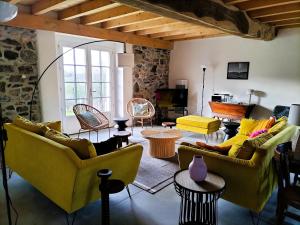 a living room with yellow couches and tables at Maison basque de charme avec piscine in Souraïde +38 photos