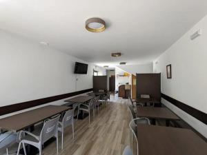 een klaslokaal met houten tafels en stoelen en een witte muur bij Albergues O Abrigo Miraz 