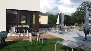 een groep stoelen, tafels en parasols bij Albergues O Abrigo Miraz 