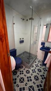 a bathroom with a shower and a toilet and a sink at El Gran Hotel in Chiquinquirá