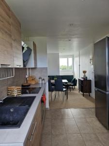 a kitchen with a counter and a dining room at Proche rocade sud in Rennes