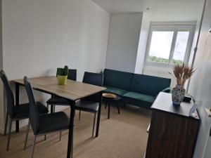 a living room with a couch and a table and chairs at Proche rocade sud in Rennes +3 photos
