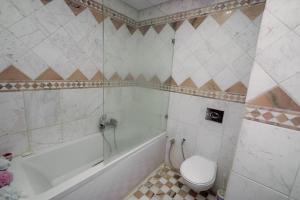 a bathroom with a tub and a toilet and a sink at Appart Julia Gammarth Sup in La Marsa +4 photos