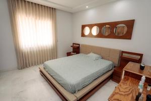 a bedroom with a bed and two mirrors on the wall at Appart Julia Gammarth Sup in La Marsa