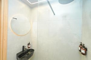 Stylish studio apartment with private yard في تريكالا: حمام مزود بحوض ومِرآة +13 صورة