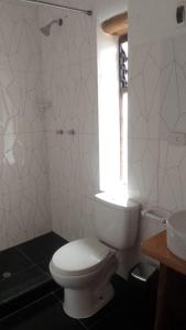 bagno bianco con servizi igienici e finestra di Casa tarawasy hostel a Urubamba