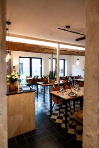 un comedor con mesas, sillas y ventanas en B&B Langeveldemolen, en Merchtem 25 fotos más
