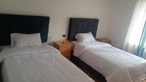 una camera da letto con due letti e un tavolo con una lampada di Casa tarawasy hostel a Urubamba