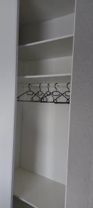 a white closet with a shelf in a room at Les heures douces - Futuroscope in Dissay +6 photos