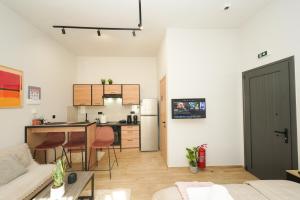 Stylish studio apartment with private yard في تريكالا: غرفة معيشة ومطبخ مع طاولة وأريكة