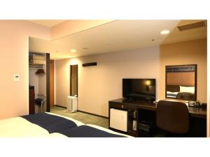 une chambre d'hôtel avec un lit, un bureau et une télévision dans l'établissement Smile Hotel Premium Kanazawa Higashiguchi Ekimae - Vacation STAY 73598v, à Housai