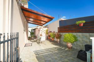 Stylish studio apartment with private yard في تريكالا: فناء به كراسي ونباتات خزفية وسياج