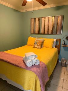 een slaapkamer met een geel bed met een handdoek erop bij Ocean Views steps to beach - Shoreline Stays 29 in Galveston +29 foto's
