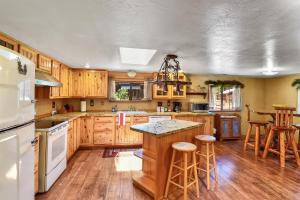 a kitchen with wooden cabinets and a island with bar stools at Rare Log Cabin Treasure Close to Grand Canyon Now with Wi-Fi in Parks