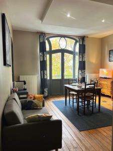 a living room with a couch and a table at T2 élégant & confortable, balcon - Amiens centre in La Celle-sous-Gouzon