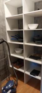 a white book shelf with bowls and dishes on it at Les heures douces - Futuroscope in Dissay