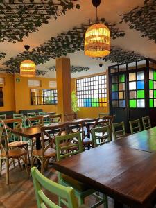 a restaurant with wooden tables and chairs and chandeliers at Casa Candelaria Hotel in Machetá +39 photos