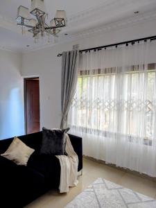 a living room with a couch and a large window at The Acacia Apartment in Lusaka