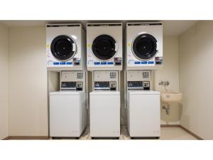 quatre machines à laver et un évier dans une pièce dans l'établissement Smile Hotel Premium Kanazawa Higashiguchi Ekimae - Vacation STAY 73601v, à Housai