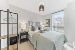 a white bedroom with a bed and a window at Lambert House Two in Harrogate