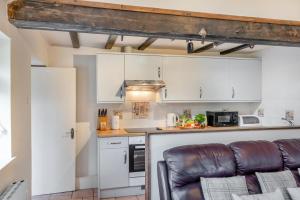 a kitchen with white cabinets and a leather couch at 2 Bed in Whitwell oc-o33499 in Whitwell +31 photos