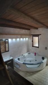 Una bañera grande en una habitación con dos ventanas. en Las Golondrinas, en Galaroza