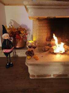Un gnomo y copas de vino junto a una chimenea en Dimora Visconti, en San Demetrio neʼ Vestini