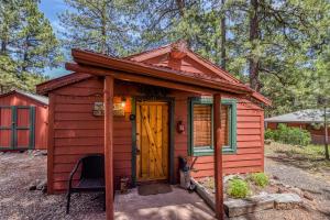 ParksにあるRustic Adventure w Historic Log Cabin Forest Views 20 minutes from Flagstaff Now with Wi-Fiの猫の居る赤小屋