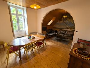 a living room with a wooden table and a couch at VILLA ILIXON - Appartements privés proche du centre de Luchon, parking, billard, jardin in Luchon
