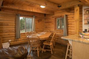a dining room with a table and chairs in a cabin at Ontario Ave Remodeled Log Cabin on 1 Acre Gateway to Grand Canyon Amazing Views in Williams