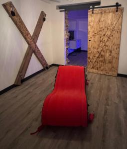 een rode stoel in een kamer met een deur bij Loveroom Montargis in Montargis