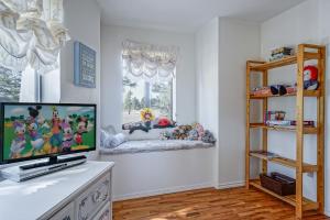 a living room with a tv and a window at Wild Bill Retreat Treehouse Acre of Fun Near Grand Canyon Williams in Williams