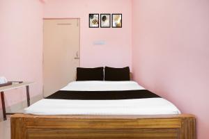 um quarto com uma cama grande com lençóis brancos em Hotel O Danapur Central Railway Junction Formerly Brij Guest House em Patna