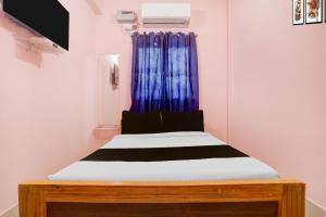 uma cama num quarto com uma cortina azul em Hotel O Danapur Central Railway Junction Formerly Brij Guest House em Patna