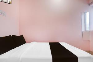 uma cama preta e branca num quarto com uma janela em Hotel O Danapur Central Railway Junction Formerly Brij Guest House em Patna