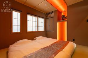 ein Schlafzimmer mit einem großen Bett mit zwei Fenstern in der Unterkunft Kyoran [Fuji Residence] - Vacation STAY 69041v in Kyōto + 36 Fotos
