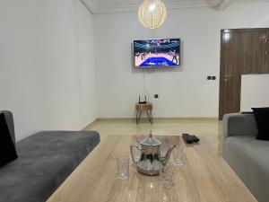 a living room with a coffee table and a tv at Appartement 2 chambres meublé Marrakech in Marrakesh
