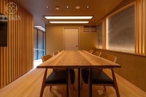 ein Konferenzraum mit einem Holztisch und Stühlen in der Unterkunft Kyoran [Fuji Residence] - Vacation STAY 69041v in Kyōto