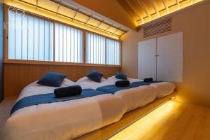 Cette chambre comprend un grand lit et de grandes fenêtres. dans l'établissement Kyoran [Gensui Residence] - Vacation STAY 69054v, à Kyōto