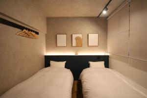 zwei Betten in einem Zimmer mit weißen Kissen in der Unterkunft YK Mansion Sannomaru 201, 202 - Vacation STAY 70704v in Kami-kumamoto