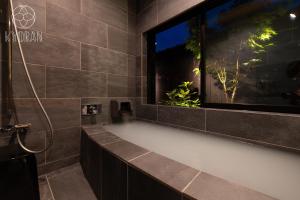 La salle de bains est pourvue d'une baignoire et d'une fenêtre. dans l'établissement Kyoran [Gensui Residence] - Vacation STAY 69054v, à Kyōto 26 autres photos