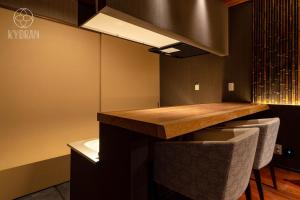 eine Küche mit einer Theke und einigen Hockern in der Unterkunft [Park Mu-seok] - Vacation STAY 69077v in Kyōto