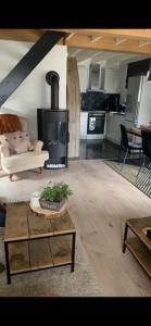 Una sala de estar con chimenea y un sofá. en Maas Lodge, en Maaseik