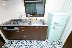 eine kleine Küche mit Spüle und Kühlschrank in der Unterkunft G-Style 405 - Vacation STAY 20485 in Shimo-mizo