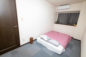 ein kleines Schlafzimmer mit einem Bett und einem Fenster in der Unterkunft G-Style 405 - Vacation STAY 20485 in Shimo-mizo