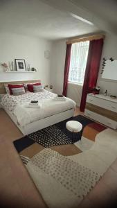 アルノルトシュタインにあるAlpine's Apartmentのベッドルーム1室(ベッド2台、スツール、窓付)