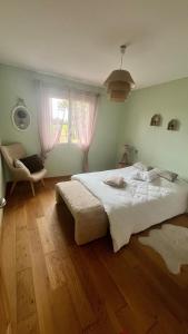 een slaapkamer met een groot wit bed en een stoel bij Maison de standing avec vue à couper le souffle ! in Molles