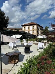 a patio with tables and umbrellas in front of a building at Hotel Olajauregi in Durango +66 photos