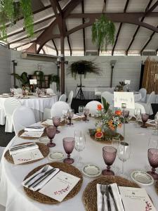 a table with white tablecloths and plates and wine glasses at Hotel Olajauregi in Durango